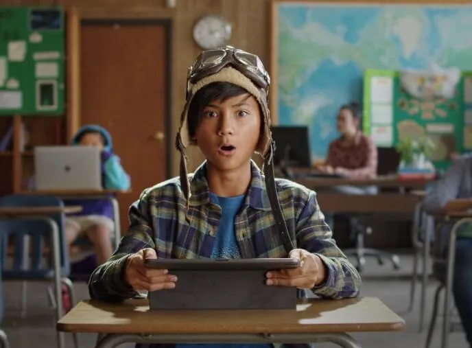 Student looking up from tablet with a surprised...