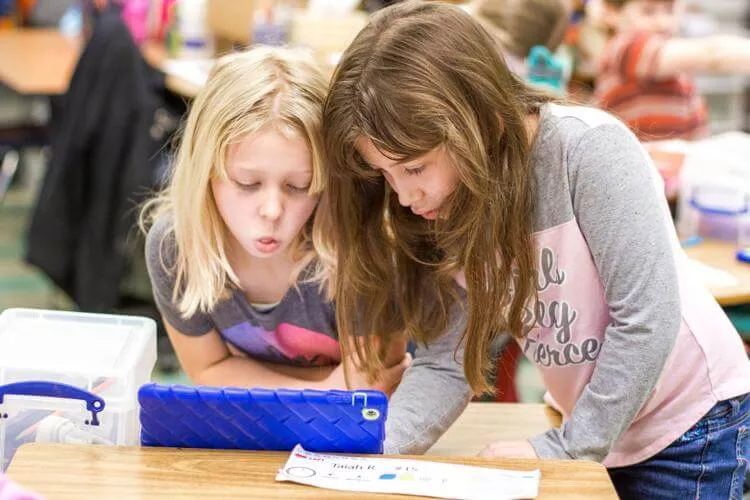 Two young female students working with iPad
