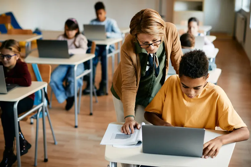 Classroom of students sitting in desks with...