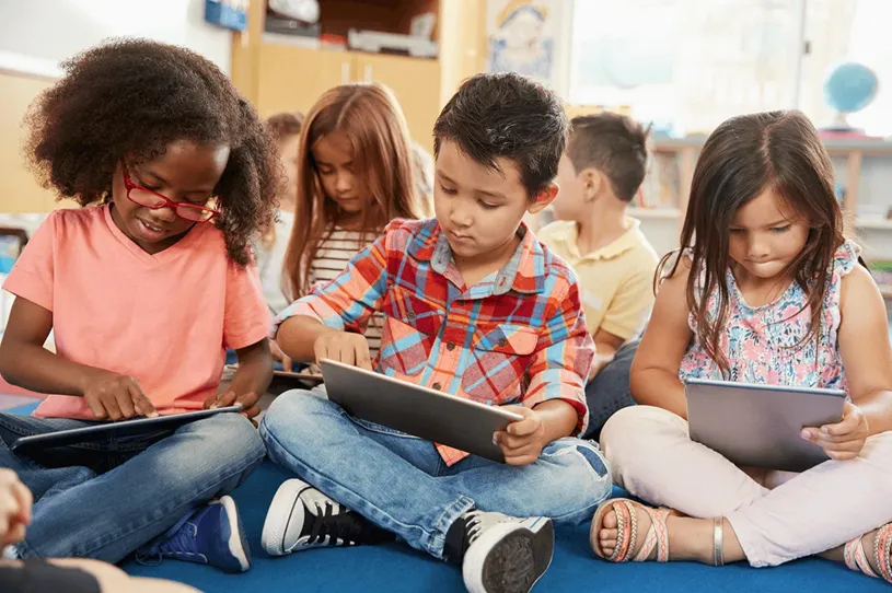 Group of younger students using handheld devices