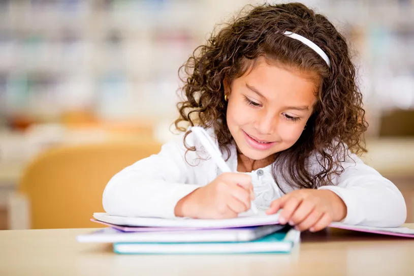 Little girl writing in a science notebook.