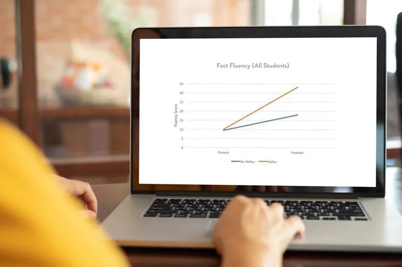 A woman focused on her laptop, analyzing a graph...