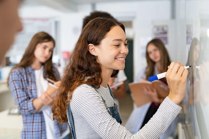 Female student working at a white board