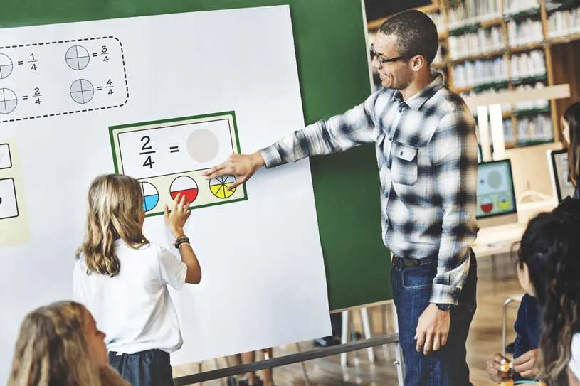 A man instructs a group of children on how to use...