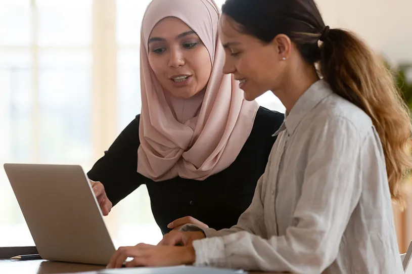 Two female teachers working together on a laptop