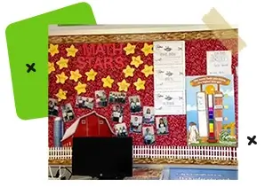A red bulleting board with stars and photos of students.