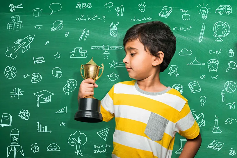 Indian student looking at an award in front of a...