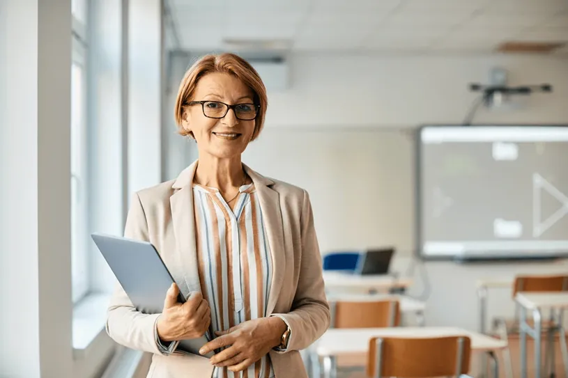 Female teacher smiling and standing in a...